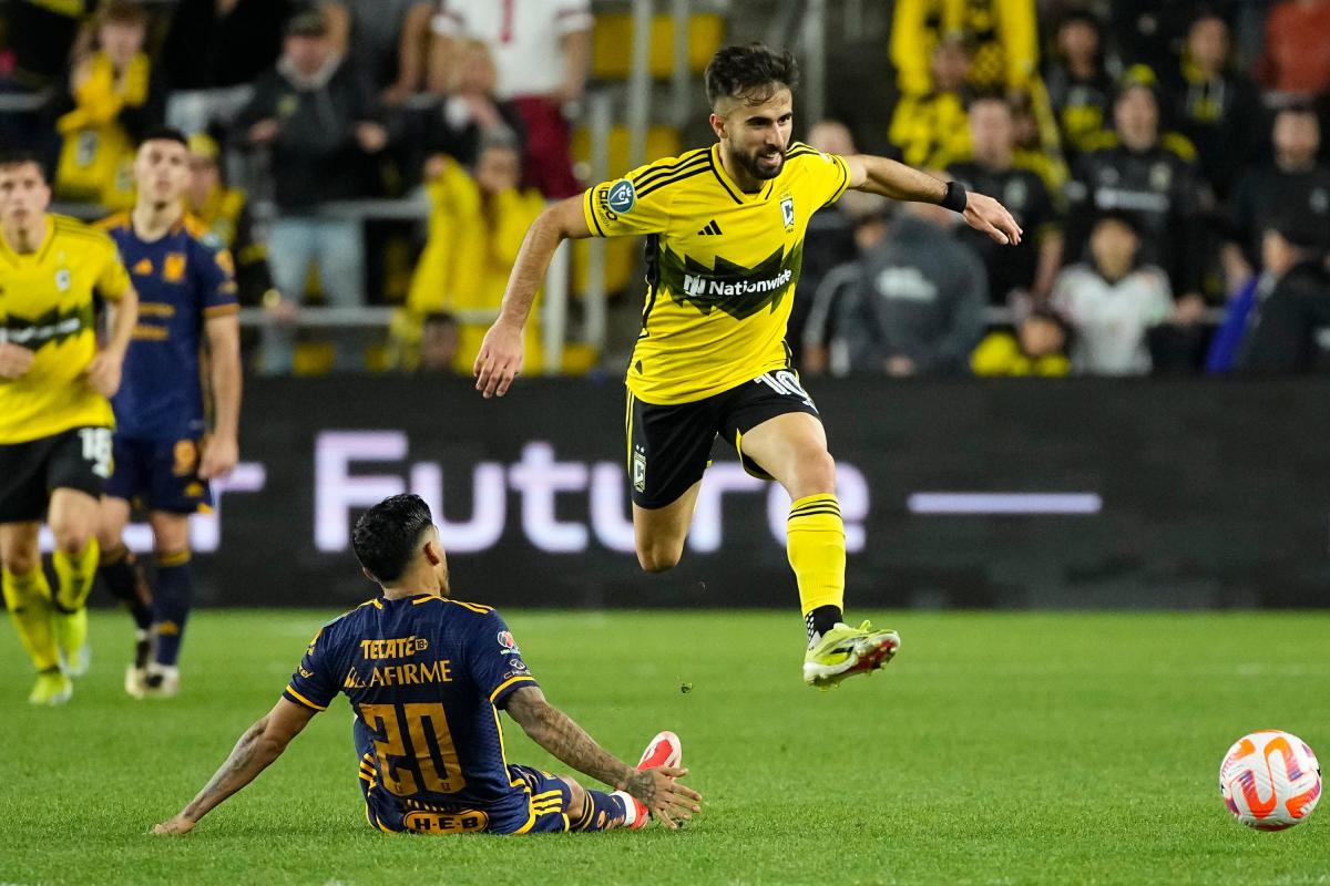 Apr 2, 2024; Columbus, OH, USA; Columbus Crew forward Diego Rossi (10) leaps over Tigres UANL midfielder Javier Aquino (20) during the second half of the Concacaf Champions Cup quarterfinal at Lower.com Field. The game ended in a 1-1 tie. Mandatory Credit: Adam Cairns-USA TODAY Sports